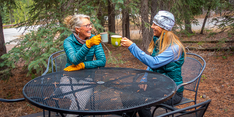 Two women sharing coffee and smiles. 
