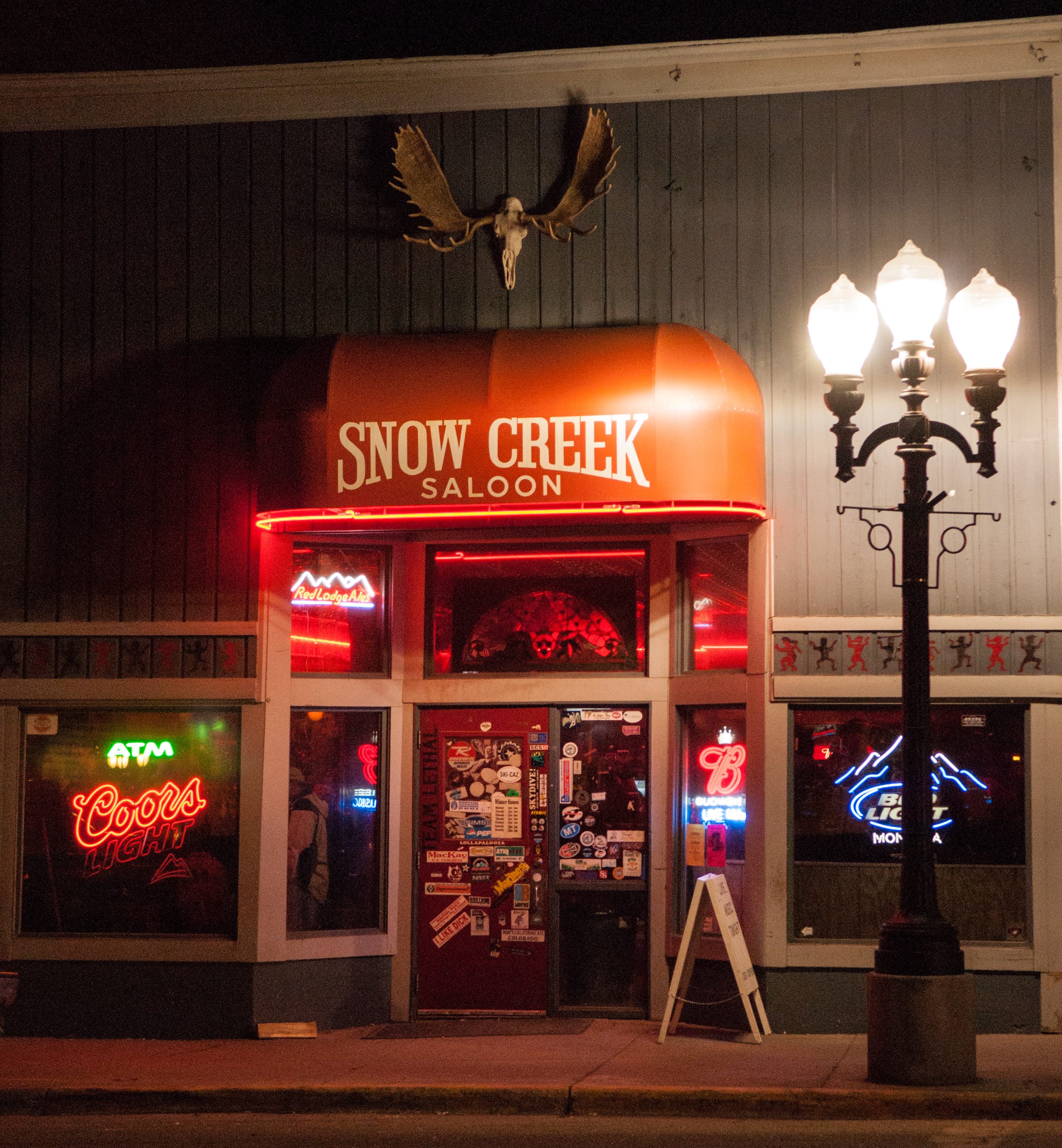 Snow Creek Saloon lit up at night in Red Lodge, Montana