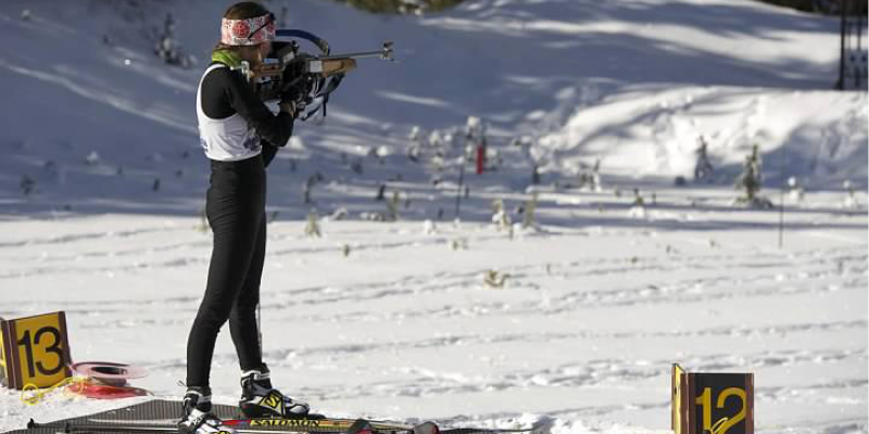 Biathlon competitor shooting at target. 