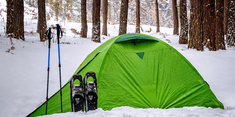 Tent with snowshoes and poles in the snow. 