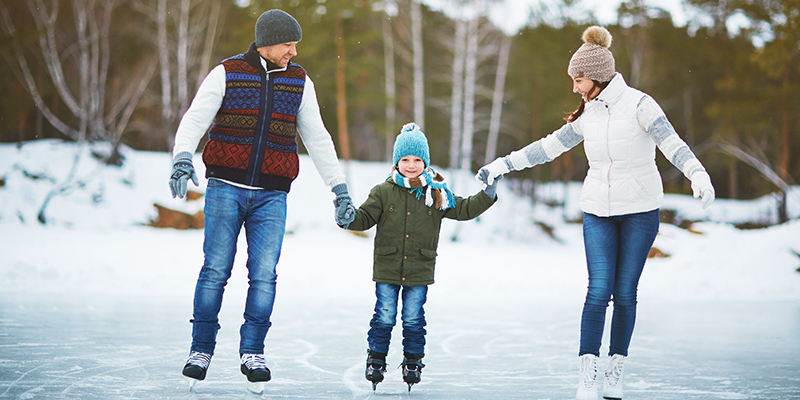 Family ice skating on outdoor rink.